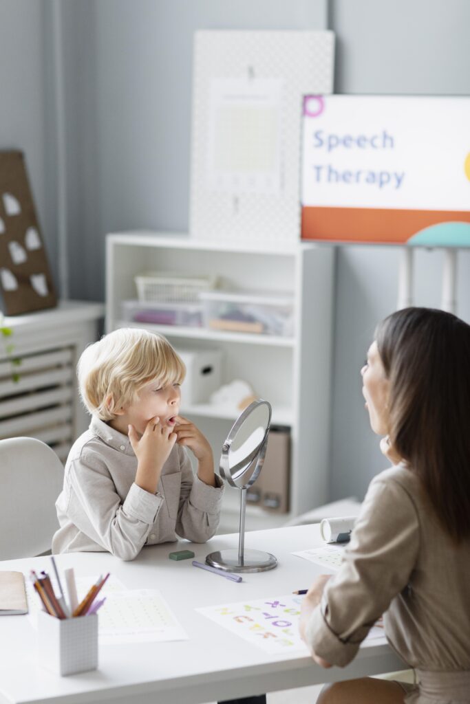 woman doing speech therapy with little boy her clinic (2)