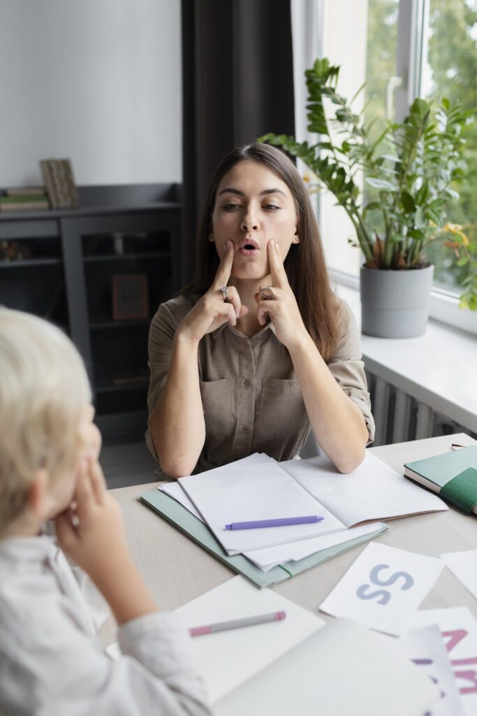 young woman doing speech therapy with little boy